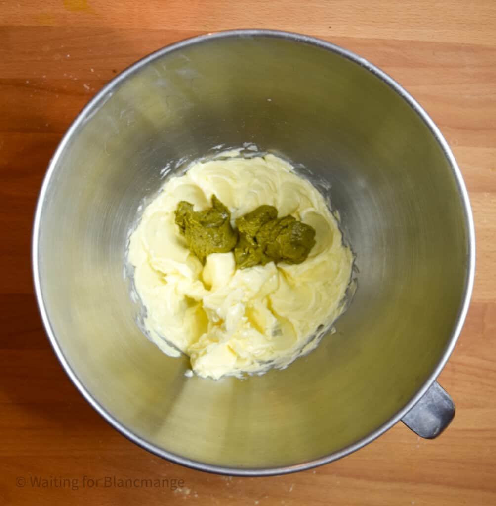 Mixing bowl from a stand mixer with butter lightly beaten and added tablespoons of pistachio nut butter.