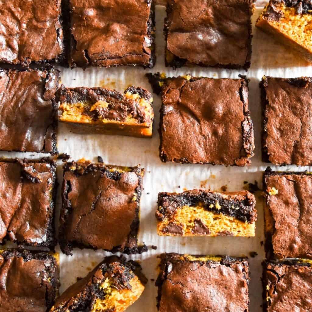 Brookies sliced and a couple on their side showing off the layers of the cookie bottomed brownies.