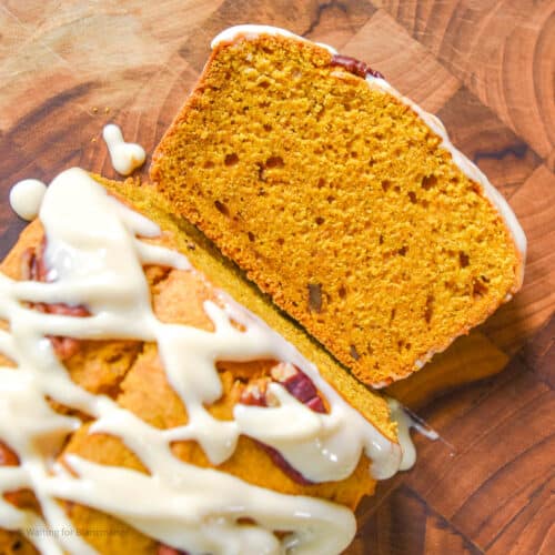 Slice of soft pumpkin pecan bread with maple cream cheese frosting.